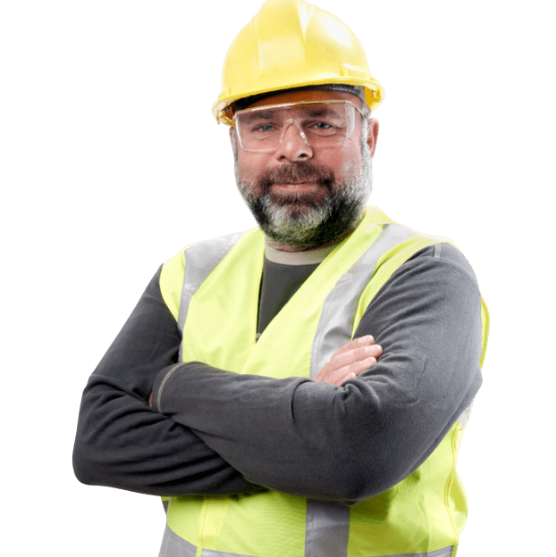 Man wearing a hard hat, safety glasses, and a reflective vest with arms crossed, standing confidently against a plain background.